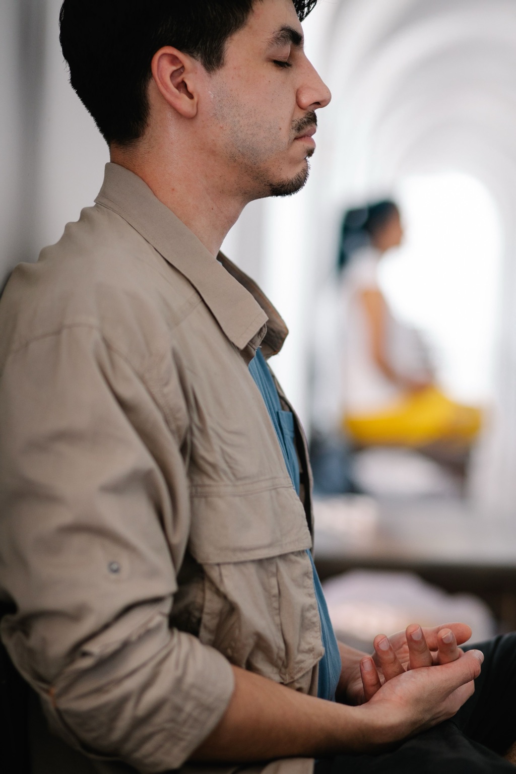 A man sits calmly with his eyes closed, practicing mindfulness