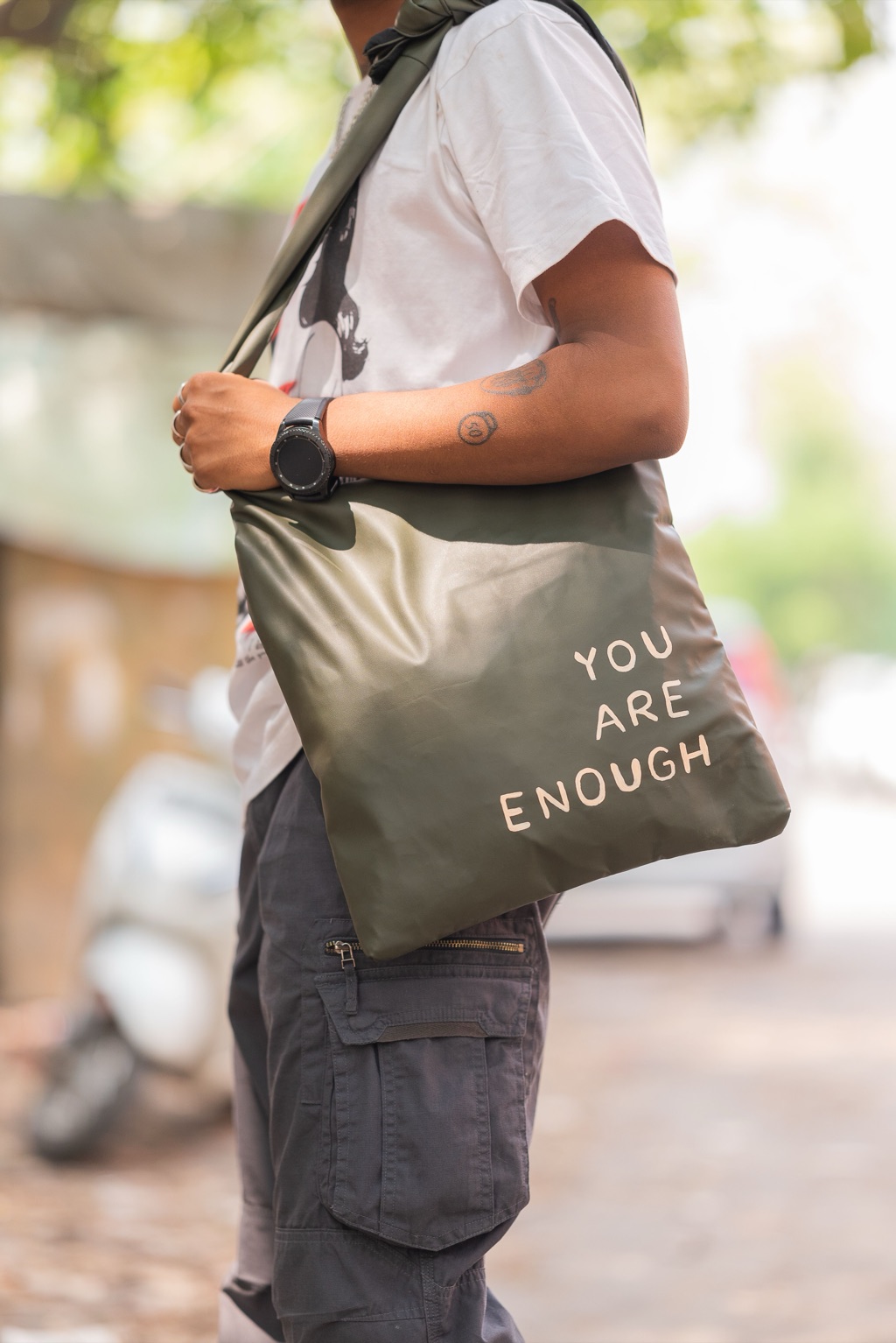 A person carrying a tote bag that reads You Are Enough