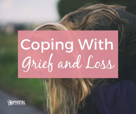 a pink rectangular box with text that reads "Coping with grief and loss" over an image of a blonde haired woman hunched over grieving with her head in her hands outside in a park.