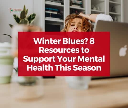 White text on partially transparent red rectangle that reads "Winter Blues: 8 Resources to Support Your Mental Health This Season" layered over a stock photo of a distressed looking white woman at a desk indoors.